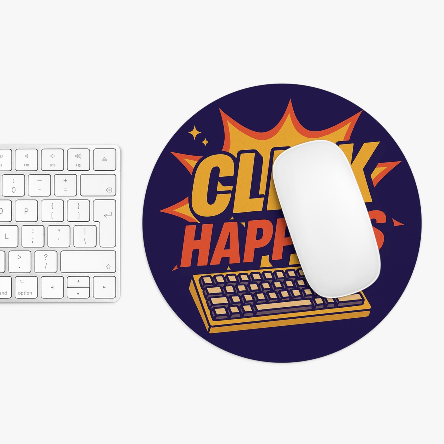 Round mouse pad with a bold “Click Happens” design placed under a white Apple mouse, styled beside a minimalist keyboard setup.